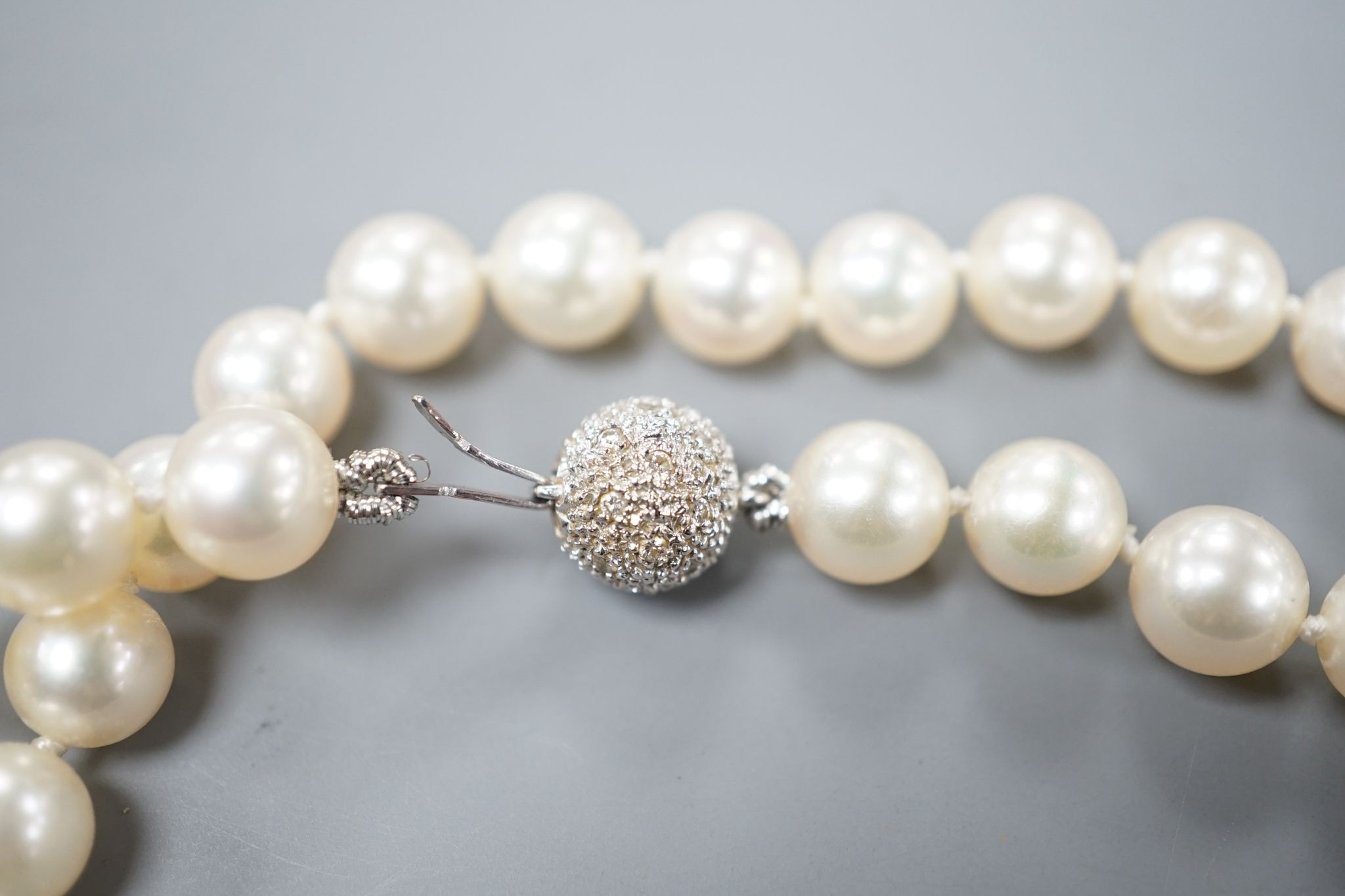 A modern single strand cultured pearl necklace, with diamond chip set spherical clasp, 72cm.